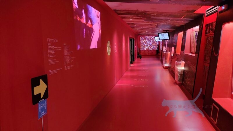 更に進むと赤い照明に照らされた通路。　壁には当時のパンフ・資料などが展示されてます。